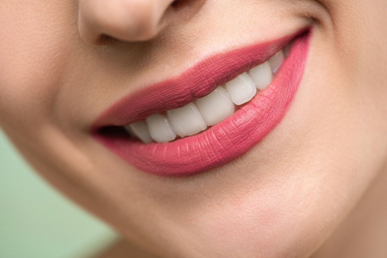 Kobieta uśmiecha się i pokazuje swoje białe zęby